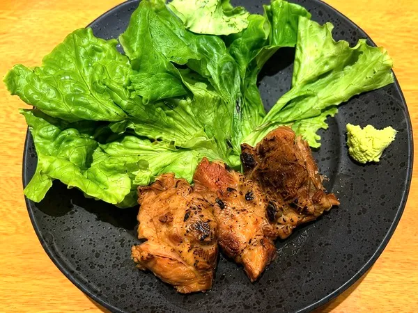 まーさん処むかいやの別皿で提供された、レタスとワサビを添えた炙り軟骨ソーキ