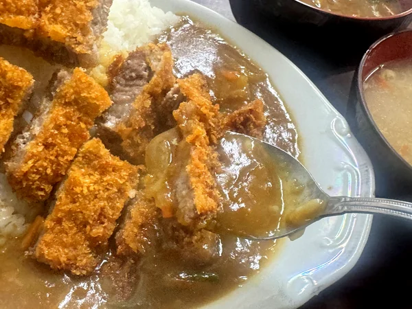 糸満市のセンター食堂で提供される、食べやすい厚さに切られたカツカレーのとんかつ