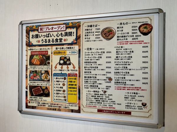 うるま市のうるまる食堂うるま店の壁に掲示されたメニュー一覧。定食や沖縄そば、まる得セットなど豊富な料理を掲載