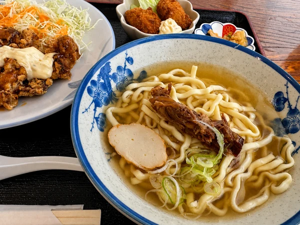 うるま市のうるまる食堂で提供された沖縄そば。軟骨ソーキやかまぼこがのった、カツオ風味のあっさりスープが楽しめる一杯