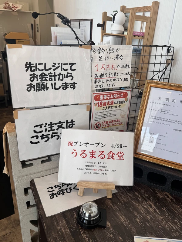 うるま市のうるまる食堂うるま店の受付案内。注文方法や先払いの案内が掲示されたカウンター