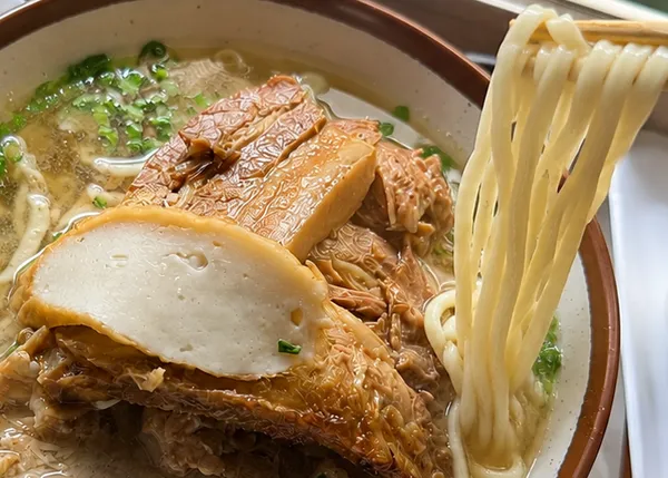 なかむら屋 浦添店のミックスそばから平麺を箸で持ち上げた様子