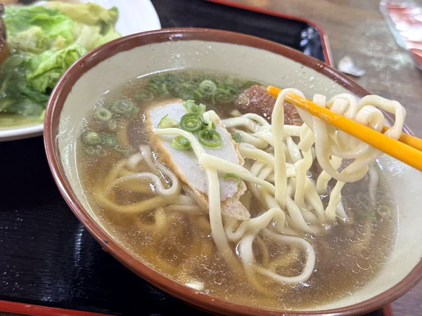 だるまそばの沖縄そばの麺を箸で持ち上げた様子