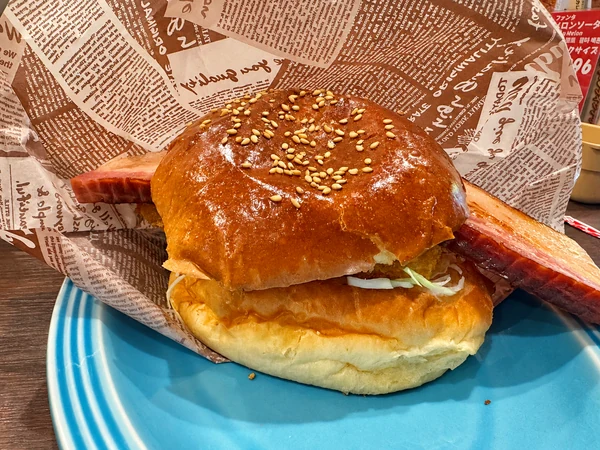 バンズから大きなビッグベーコンがはみ出したチキンカツカレーバーガー