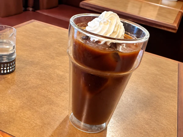 沖縄市の珈琲の館で注文した550円のアイスカフェモカ。グラスの上にホイップクリームがのった一杯