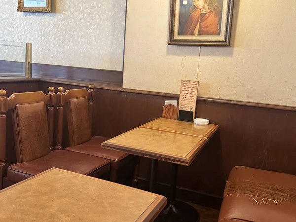 珈琲の館の4人掛けテーブル席。木製テーブルと茶色の背もたれ付き椅子が並ぶ店内