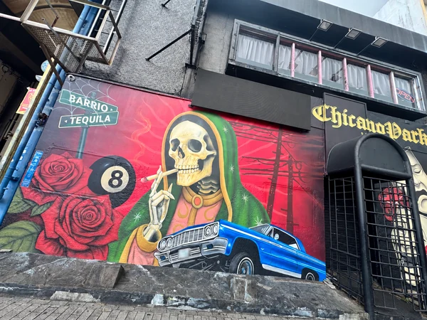 沖縄市コザの建物に描かれた骸骨と青いローライダーのカラフルな壁画。珈琲の館からの街歩きで撮影